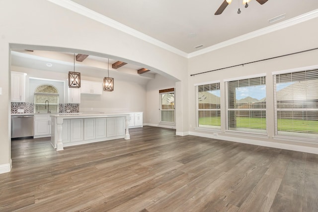 302 Micco Ln, Rockwall, TX 75087 - unfurnished living room featuring ceiling fan, wood finished floors, arched walkways, baseboards, and crown molding