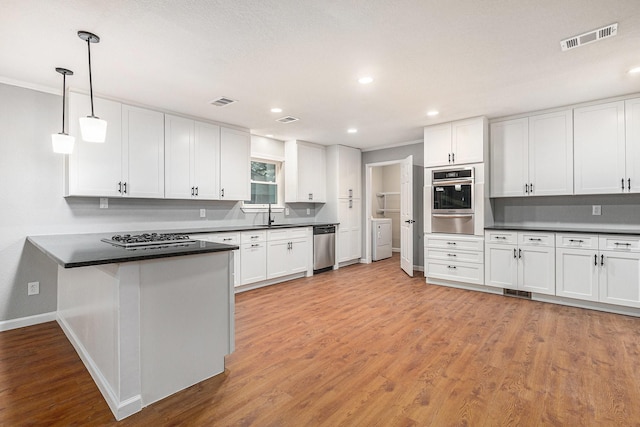 6412 Regal Rd, Forest Hill, TX 76119 - kitchen featuring stainless steel appliances, dark countertops, a warming drawer, a peninsula, and recessed lighting