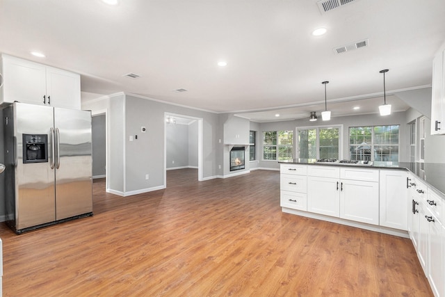 6412 Regal Rd, Forest Hill, TX 76119 - kitchen with stainless steel refrigerator with ice dispenser, open floor plan, ornamental molding, white gas stovetop, and white cabinets