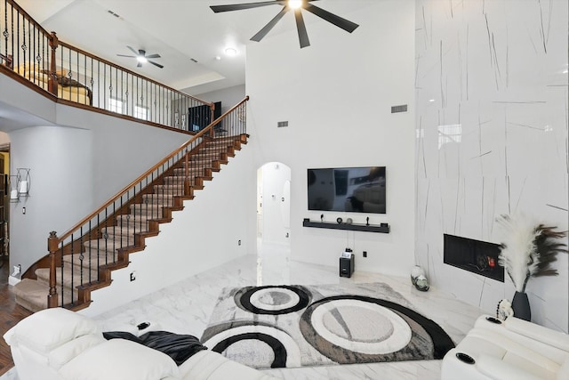 1330 Billingsley Dr, Waxahachie, TX 75167 - living area featuring a ceiling fan, stairway, a high ceiling, arched walkways, and marble tiled floors
