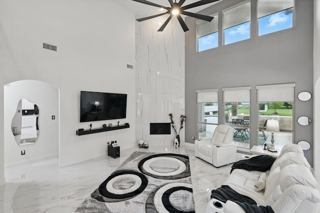 1330 Billingsley Dr, Waxahachie, TX 75167 - living area featuring a high ceiling, marble tiled floors, a ceiling fan, arched walkways, and baseboards
