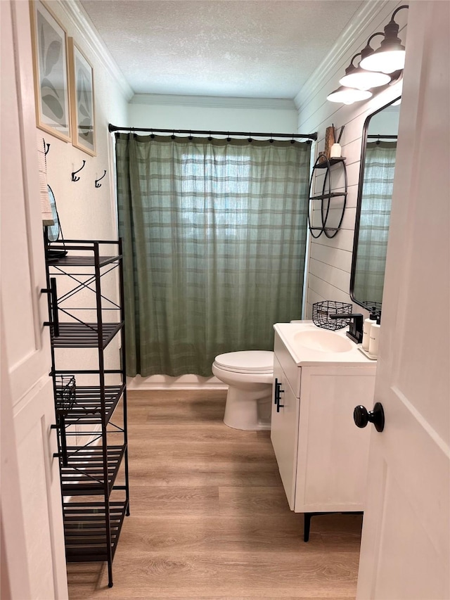 107 S Lakeview Dr, Lacy Lakeview, TX 76705 - full bathroom featuring ornamental molding, toilet, vanity, wood finished floors, and a textured ceiling