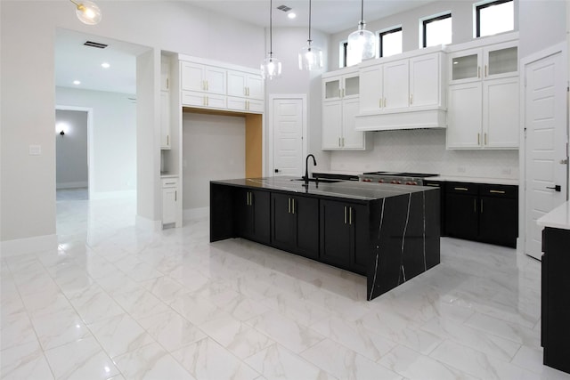 10787 Leake Ln, Frisco, TX 75035 - kitchen with dark cabinetry, a sink, white cabinetry, a center island with sink, and decorative backsplash