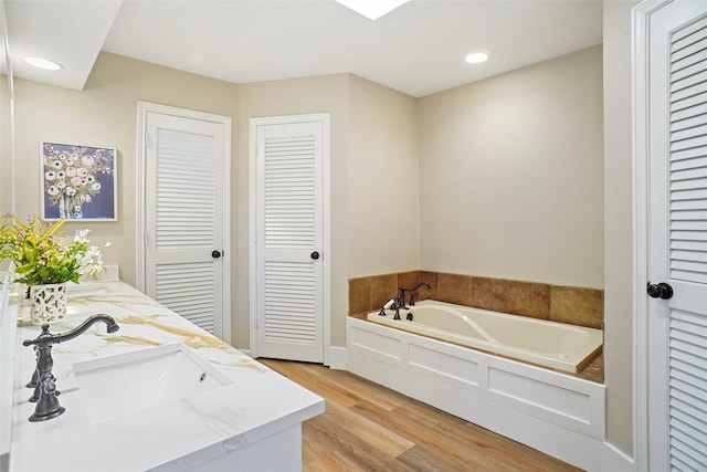 7208 Maranatha Ct, Colleyville, TX 76034 - bathroom with a closet, double vanity, a garden tub, wood finished floors, and recessed lighting