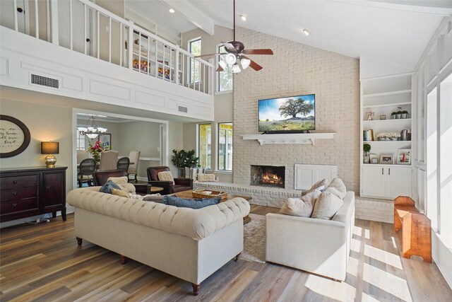 7208 Maranatha Ct, Colleyville, TX 76034 - living area featuring wood finished floors, beam ceiling, ceiling fan, a brick fireplace, and a chandelier