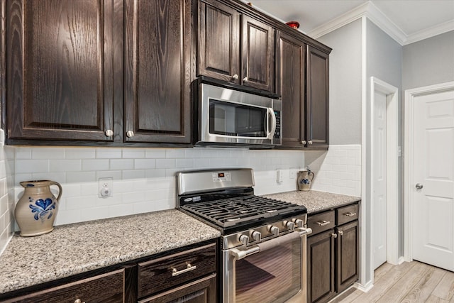901 Freesia Dr, Little Elm, TX 75068 - kitchen featuring stainless steel appliances, crown molding, light wood finished floors, dark brown cabinets, and backsplash
