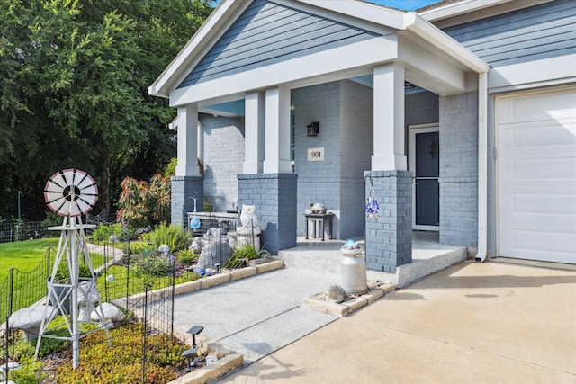901 Freesia Dr, Little Elm, TX 75068 - doorway to property with a porch, brick siding, driveway, and a garage