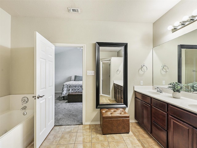 157 Castleridge Dr Unit B, Little Elm, TX 75068 - ensuite bathroom with double vanity, a bath, tile patterned flooring, and baseboards