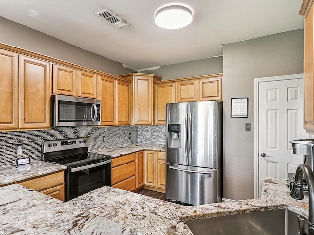 157 Castleridge Dr Unit B, Little Elm, TX 75068 - kitchen featuring stainless steel appliances, light stone countertops, backsplash, a sink, and wood finished floors