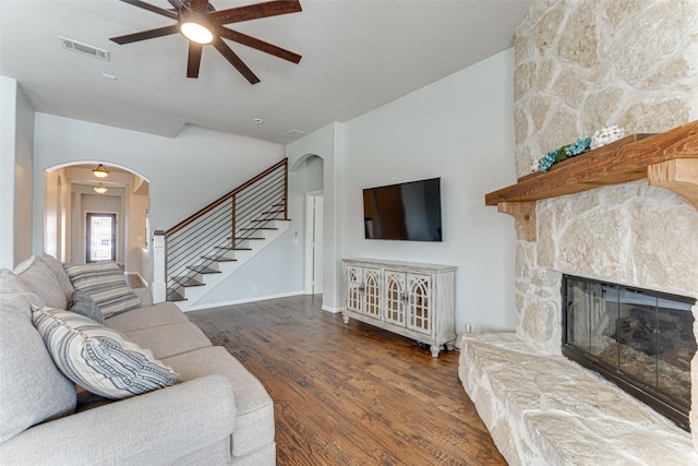 1012 Honeywell Dr, Anna, TX 75409 - living area featuring arched walkways, a stone fireplace, ceiling fan, wood finished floors, and stairway