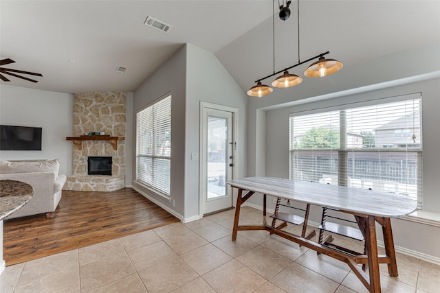 1012 Honeywell Dr, Anna, TX 75409 - dining area featuring light tile patterned floors, a fireplace, a ceiling fan, baseboards, and vaulted ceiling