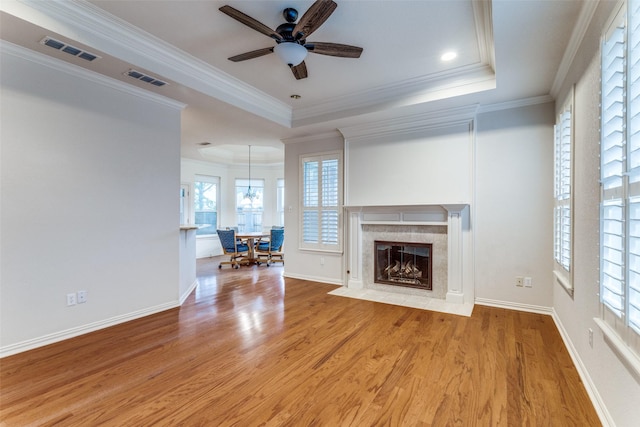 805 Evergreen Ct, Keller, TX 76248 - unfurnished living room featuring light wood-style floors, ceiling fan, a raised ceiling, a high end fireplace, and crown molding
