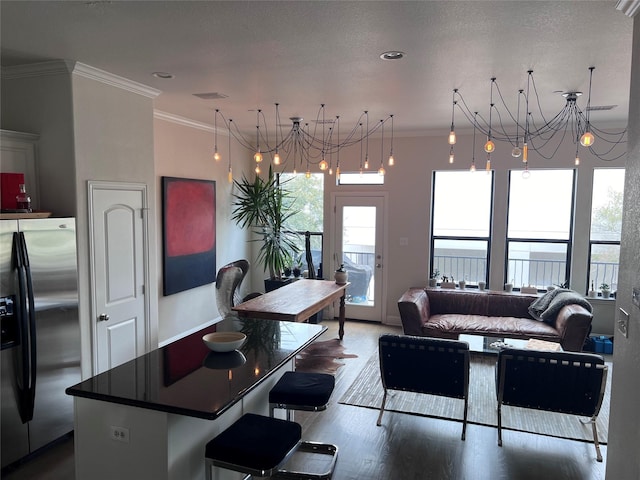 5701 Pantheon Ct, Plano, TX 75024 - kitchen with stainless steel fridge, crown molding, a chandelier, wood finished floors, and a center island