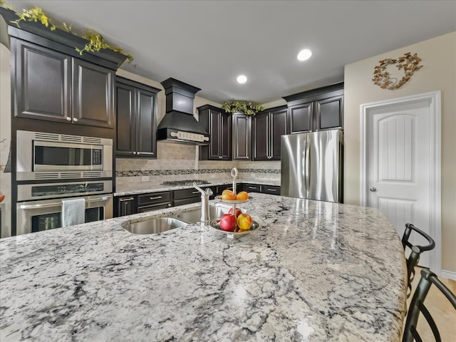 1316 Heather Ln, Little Elm, TX 75068 - kitchen featuring appliances with stainless steel finishes, premium range hood, light stone counters, tasteful backsplash, and recessed lighting