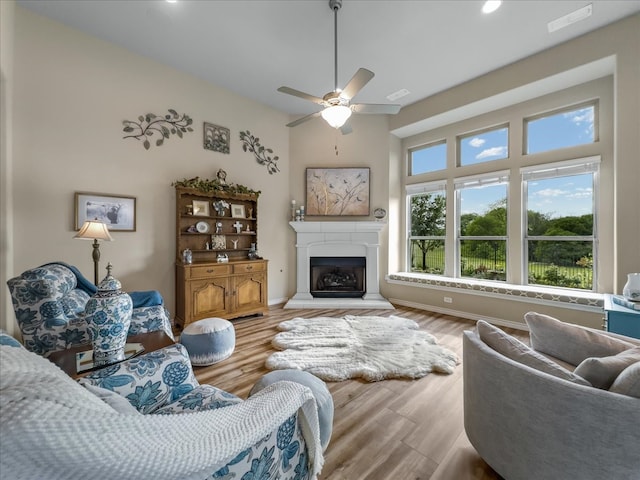 1316 Heather Ln, Little Elm, TX 75068 - living room with a ceiling fan, wood finished floors, a fireplace with raised hearth, and recessed lighting