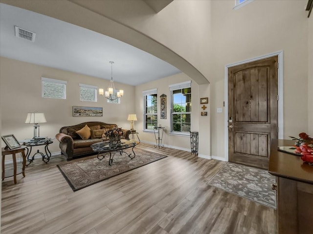1316 Heather Ln, Little Elm, TX 75068 - living room featuring wood finished floors, arched walkways, and a chandelier