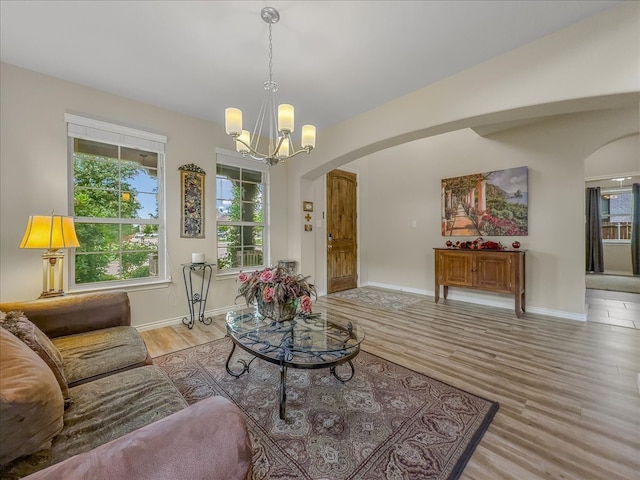 1316 Heather Ln, Little Elm, TX 75068 - living room with arched walkways, wood finished floors, and a chandelier
