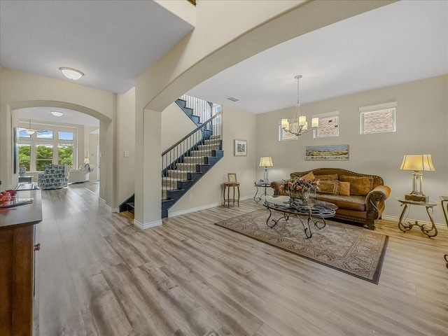 1316 Heather Ln, Little Elm, TX 75068 - living room with stairway, wood finished floors, arched walkways, and a chandelier