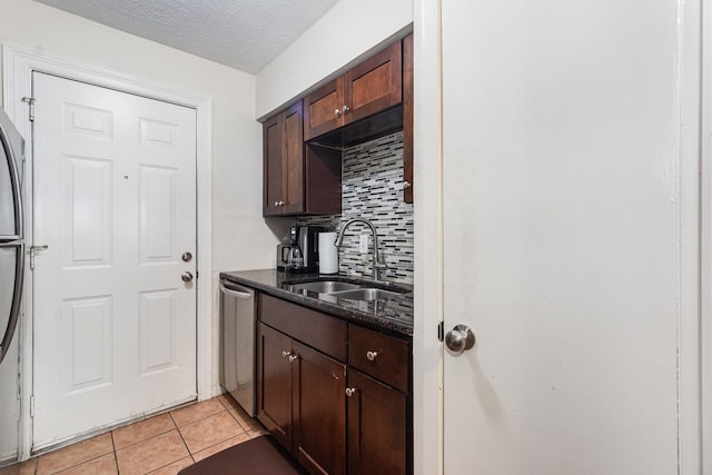 4317 Hartford St Unit 102, Dallas, TX 75219 - kitchen featuring stainless steel dishwasher, backsplash, light tile patterned floors, dark brown cabinetry, and a textured ceiling