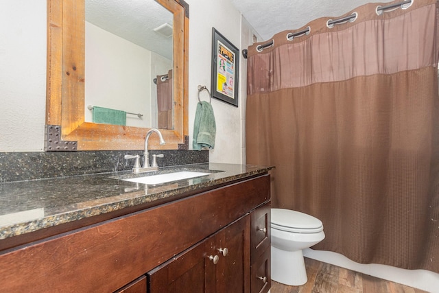 4317 Hartford St Unit 102, Dallas, TX 75219 - bathroom featuring wood finished floors, vanity, and a textured ceiling