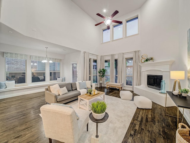 413 Winehart St, Lewisville, TX 75056 - living area featuring a chandelier, a fireplace with raised hearth, wood finished floors, ceiling fan, and a high ceiling