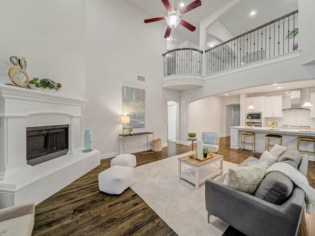 413 Winehart St, Lewisville, TX 75056 - living room featuring ceiling fan, dark wood-type flooring, arched walkways, high vaulted ceiling, and baseboards