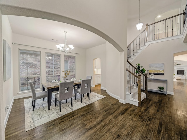 413 Winehart St, Lewisville, TX 75056 - dining space featuring arched walkways, wood finished floors, stairway, a chandelier, and a high ceiling