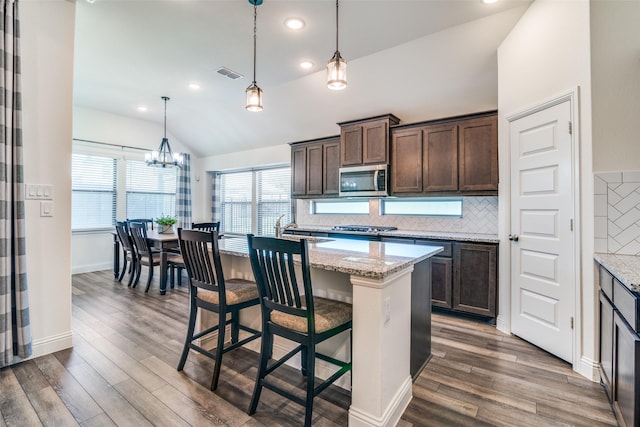 200 Tallgrass Dr, Lavon, TX 75166 - kitchen with stainless steel microwave, lofted ceiling, dark brown cabinets, dark wood finished floors, and a chandelier
