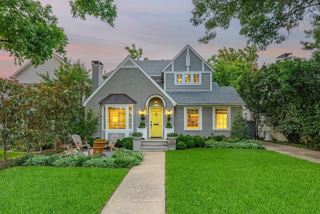 5507 W Amherst Ave, Dallas, TX 75209 - view of front of property featuring a shingled roof, a front yard, brick siding, and a chimney