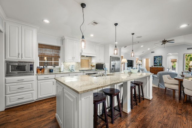 5507 W Amherst Ave, Dallas, TX 75209 - kitchen with appliances with stainless steel finishes, white cabinets, recessed lighting, a large island, and decorative backsplash