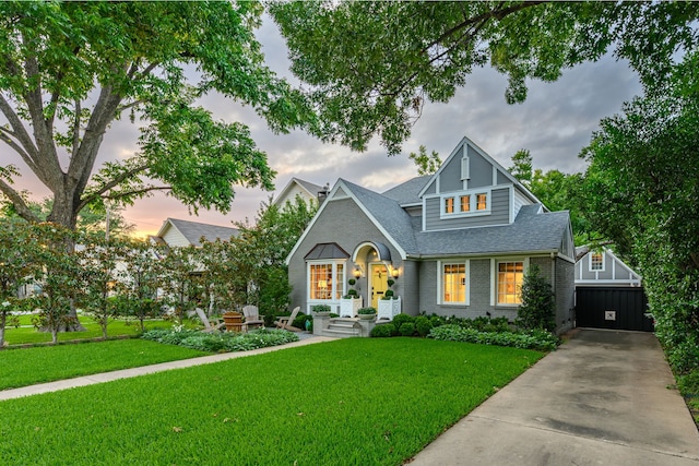 5507 W Amherst Ave, Dallas, TX 75209 - view of front of home with brick siding, roof with shingles, a lawn, an outdoor structure, and driveway