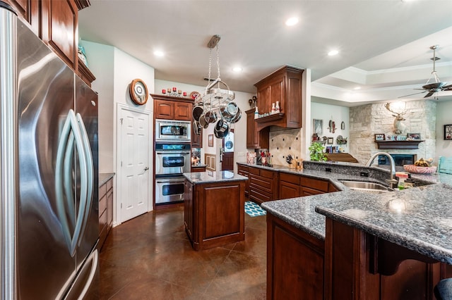 4401 Oak Shores Cir, Cross Roads, TX 76227 - kitchen featuring appliances with stainless steel finishes, a sink, a ceiling fan, a center island, and a fireplace