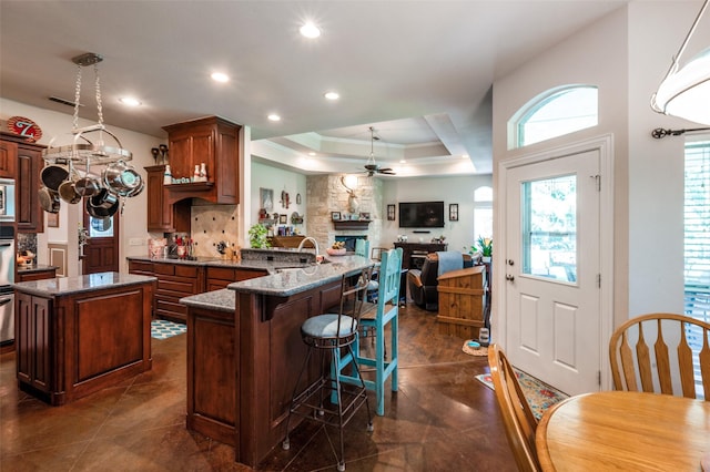 4401 Oak Shores Cir, Cross Roads, TX 76227 - kitchen with a ceiling fan, a peninsula, dark stone countertops, recessed lighting, and a center island