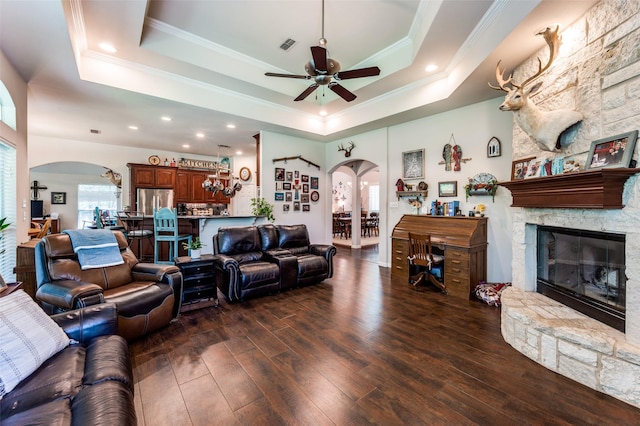 4401 Oak Shores Cir, Cross Roads, TX 76227 - living room featuring arched walkways, a raised ceiling, hardwood / wood-style flooring, ceiling fan, and a fireplace