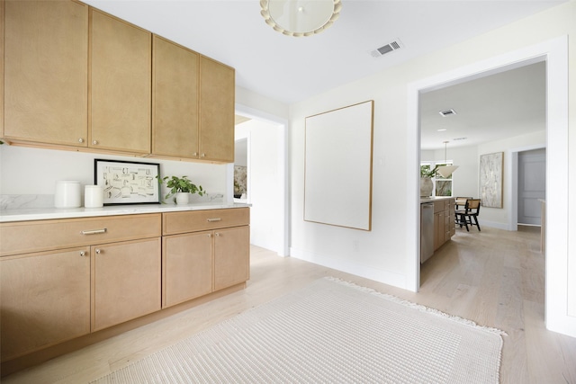 7716 Roundrock Rd, Dallas, TX 75248 - kitchen featuring light wood-type flooring, light countertops, light brown cabinetry, and dishwasher