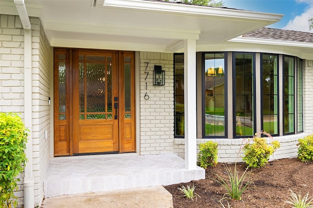 7716 Roundrock Rd, Dallas, TX 75248 - doorway to property with brick siding and roof with shingles