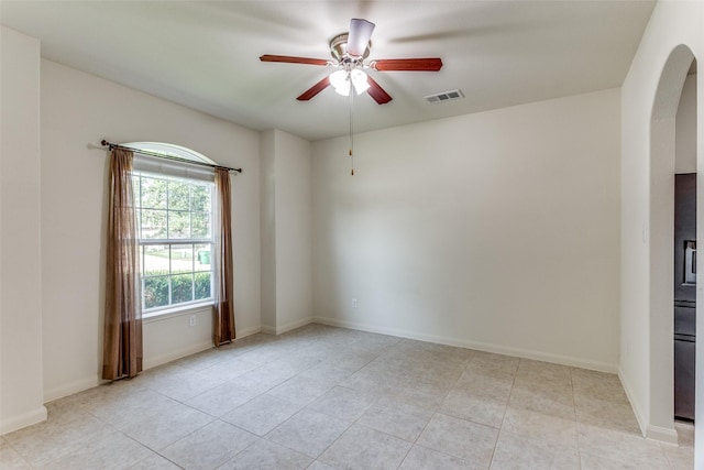 4201 Tower Ln, Crowley, TX 76036 - unfurnished room with arched walkways, a ceiling fan, light tile patterned flooring, and baseboards