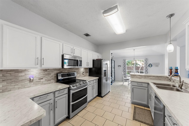 2312 Collier Dr, Mckinney, TX 75071 - kitchen with stainless steel appliances, a sink, a textured ceiling, light countertops, and tasteful backsplash