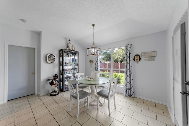 2312 Collier Dr, Mckinney, TX 75071 - dining room featuring a chandelier, a textured ceiling, baseboards, light tile patterned floors, and lofted ceiling