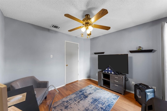 2312 Collier Dr, Mckinney, TX 75071 - living area with wood finished floors, a ceiling fan, baseboards, and a textured ceiling