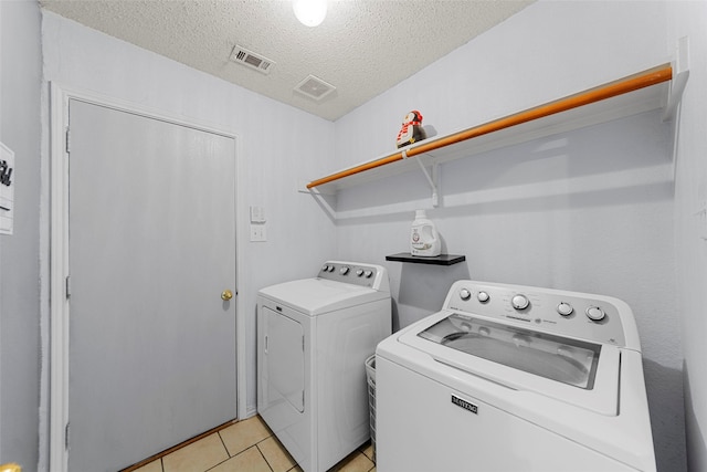 2312 Collier Dr, Mckinney, TX 75071 - laundry area with separate washer and dryer, a textured ceiling, and light tile patterned flooring