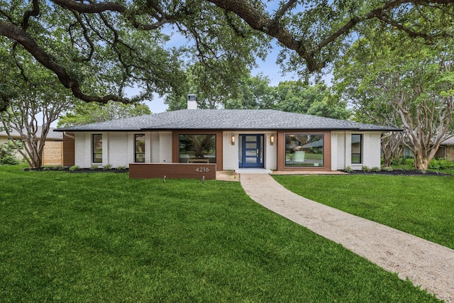 4216 Rickover Dr, Dallas, TX 75244 - view of front of home with a front lawn, a chimney, brick siding, and roof with shingles