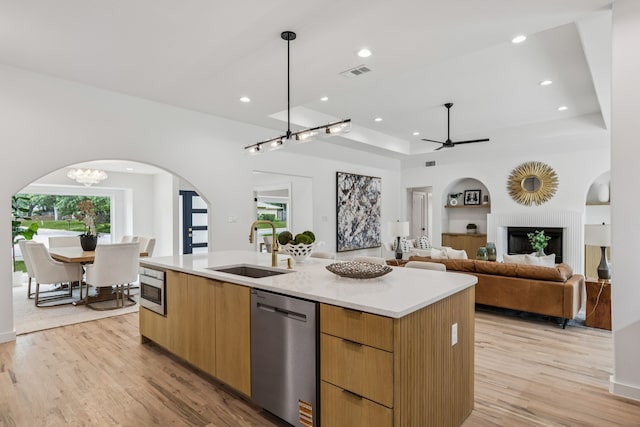 4216 Rickover Dr, Dallas, TX 75244 - kitchen featuring stainless steel appliances, a sink, modern cabinets, arched walkways, and light wood-style floors
