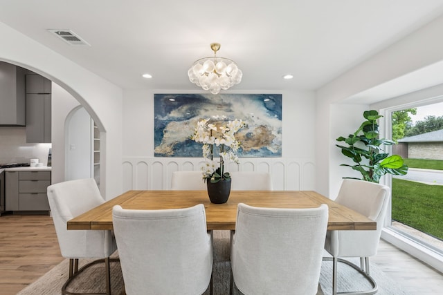 4216 Rickover Dr, Dallas, TX 75244 - dining area featuring light wood finished floors, a chandelier, arched walkways, recessed lighting, and wainscoting