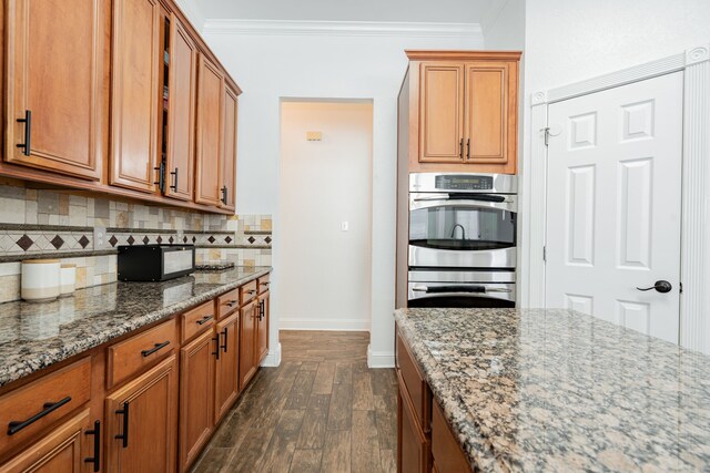 1005 Ruidoso Downs Dr, Talty, TX 75160 - kitchen featuring dark wood finished floors, double oven, crown molding, light stone counters, and backsplash