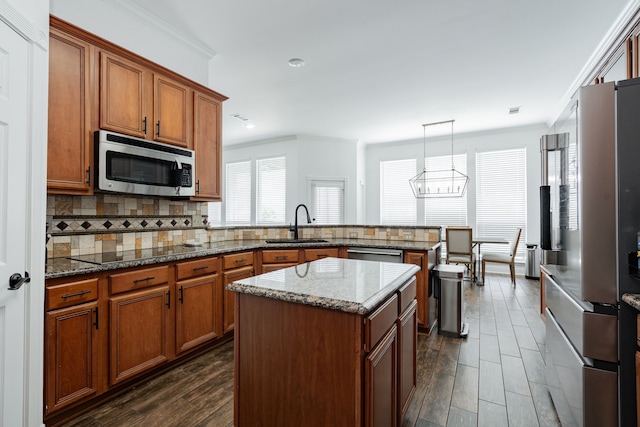 1005 Ruidoso Downs Dr, Talty, TX 75160 - kitchen with appliances with stainless steel finishes, a peninsula, brown cabinetry, decorative backsplash, and ornamental molding