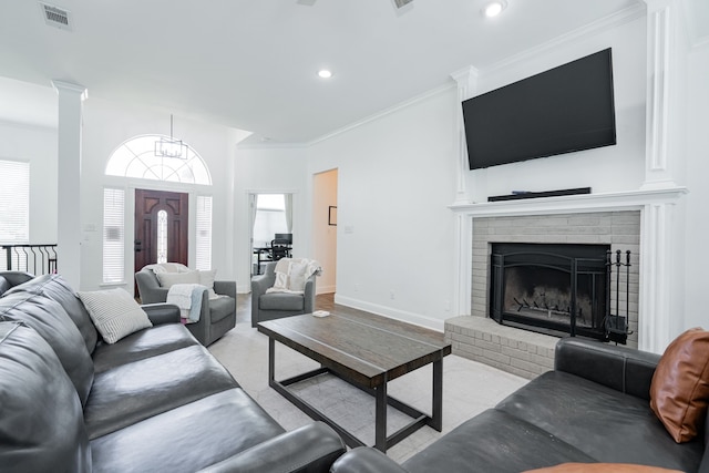 1005 Ruidoso Downs Dr, Talty, TX 75160 - living room with crown molding, recessed lighting, a brick fireplace, and ornate columns