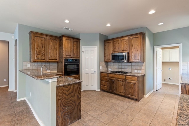 1908 Canyon Wren Dr, Mckinney, TX 75071 - kitchen with black appliances, dark stone countertops, light tile patterned floors, decorative backsplash, and recessed lighting