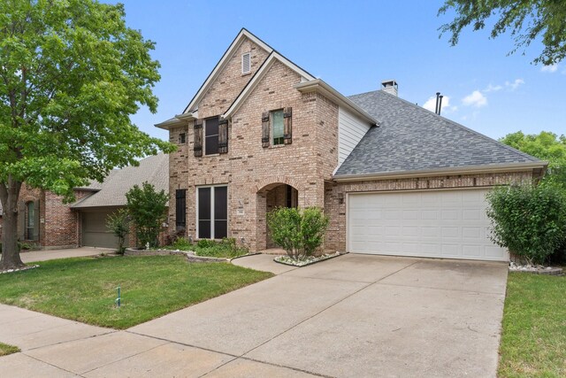 1908 Canyon Wren Dr, Mckinney, TX 75071 - traditional-style house featuring a shingled roof, brick siding, a garage, a front yard, and concrete driveway