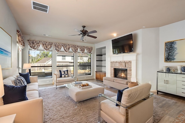 1908 Canyon Wren Dr, Mckinney, TX 75071 - living area featuring a ceiling fan, wood finished floors, a fireplace, and built in features
